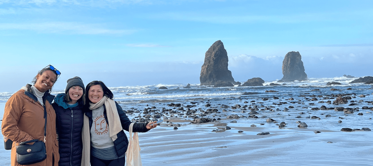 Rebeka, Kelly, and Weina on Cannon Beach at 2023 Crag Staff Retreat